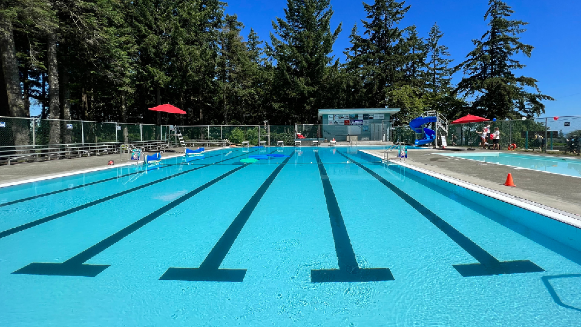 pool with swimming lanes and a water slide in the background.