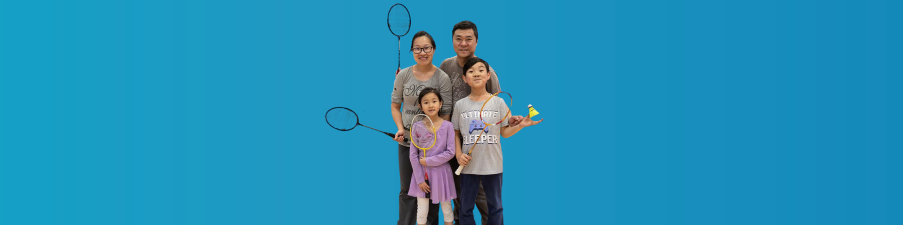 The Recreation Guide Cover has a family of four people smiling with their arms around each other and holding badminton rackets.