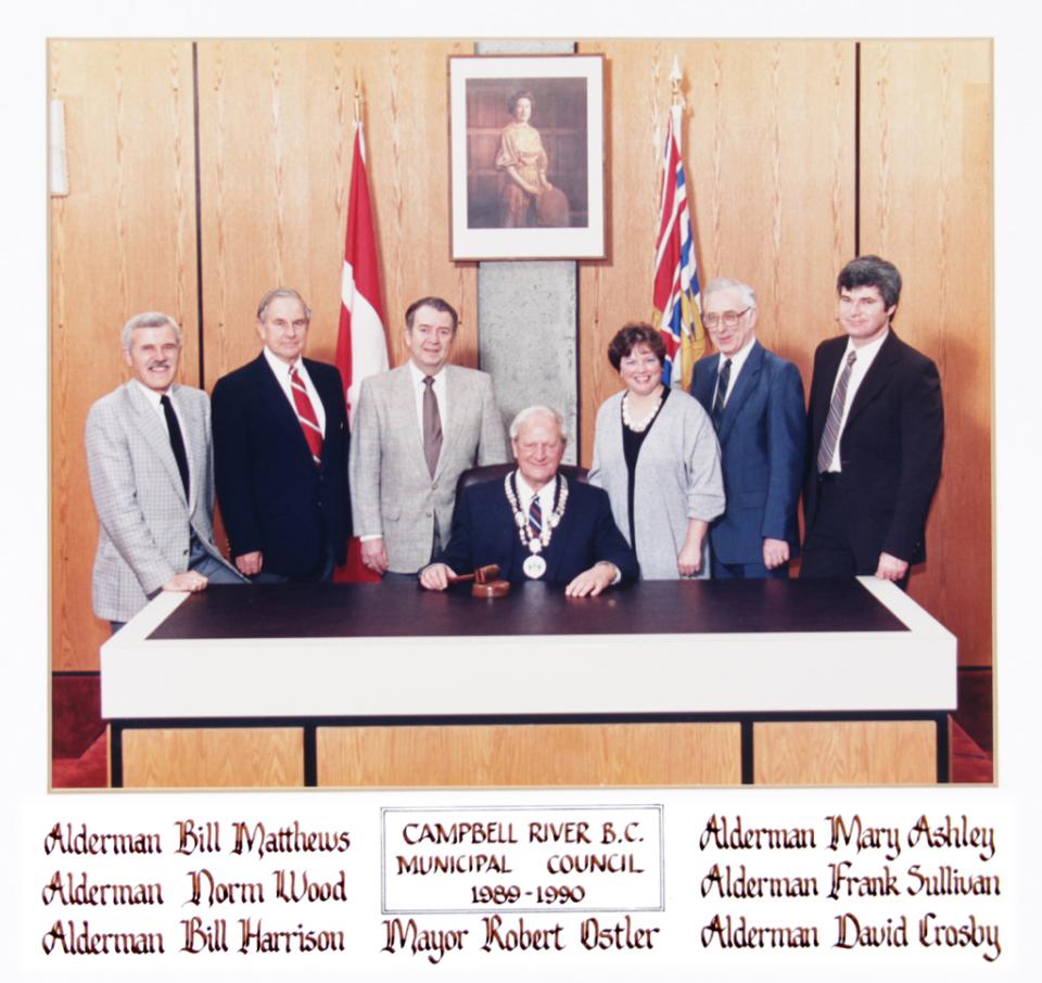 Group of eight people around a table in a formal setting.