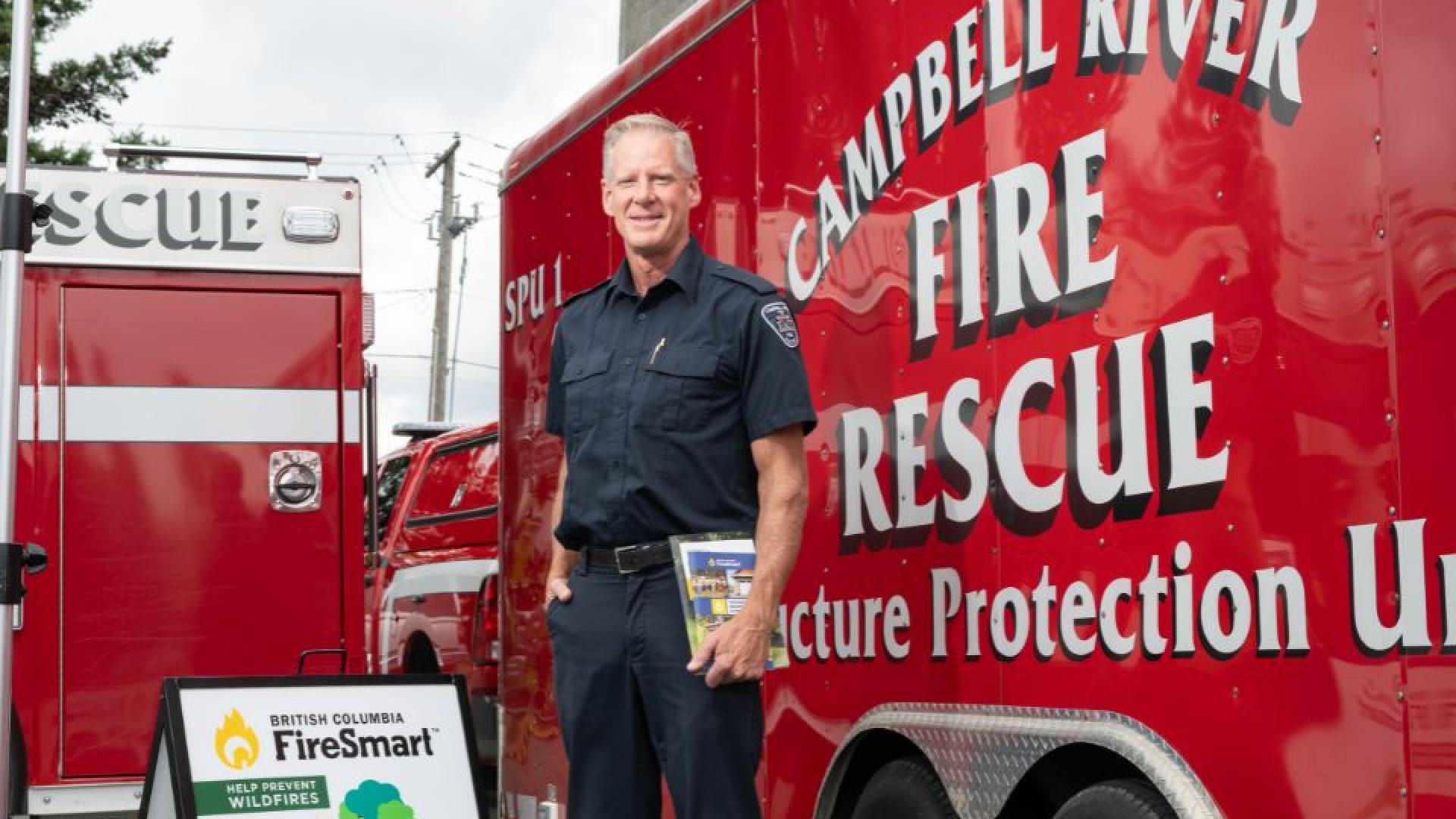 Fire Fighter stands in front of a Campbell River Fire Rescue truck.