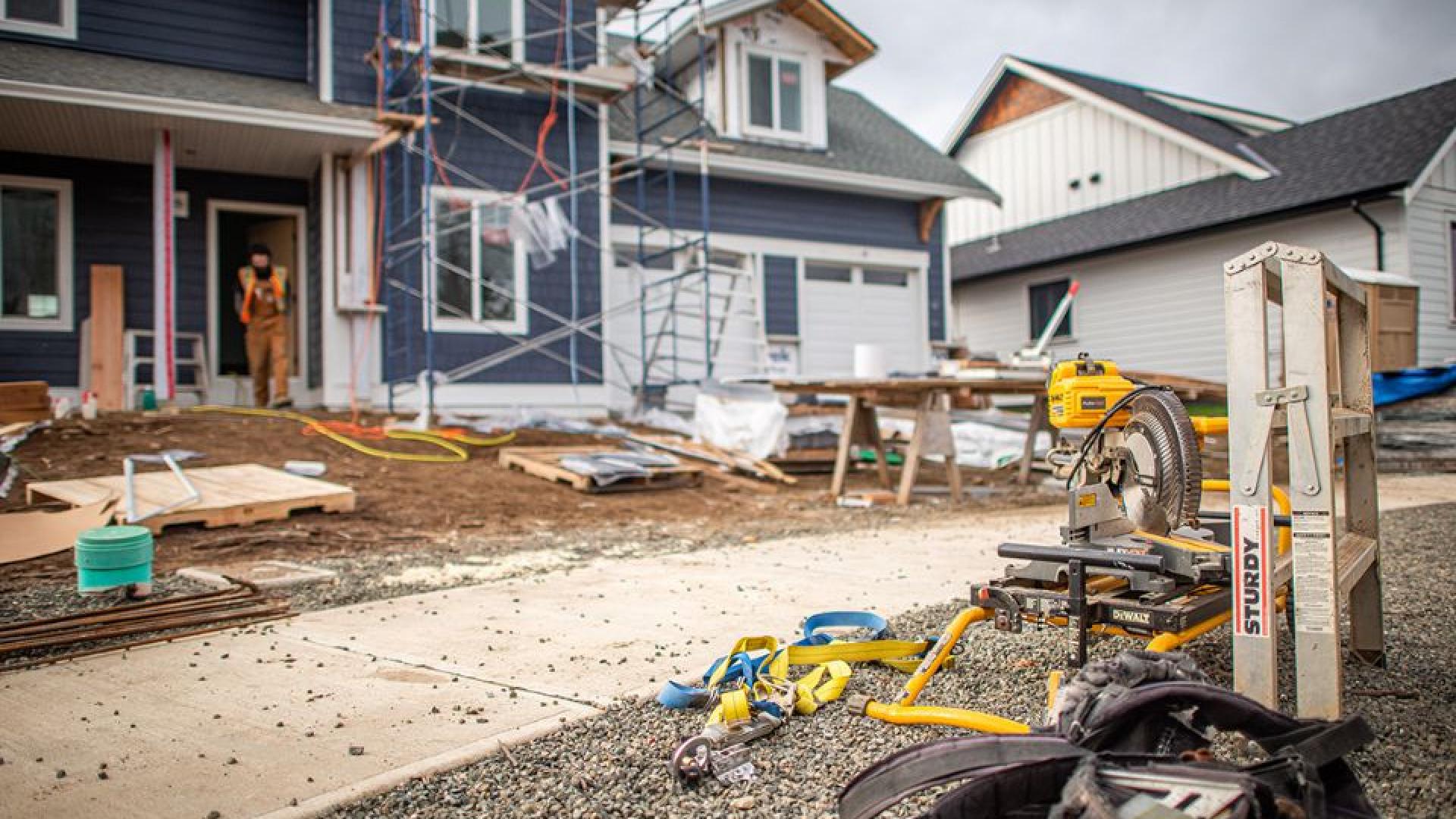 House under construction with power tools on the ground.