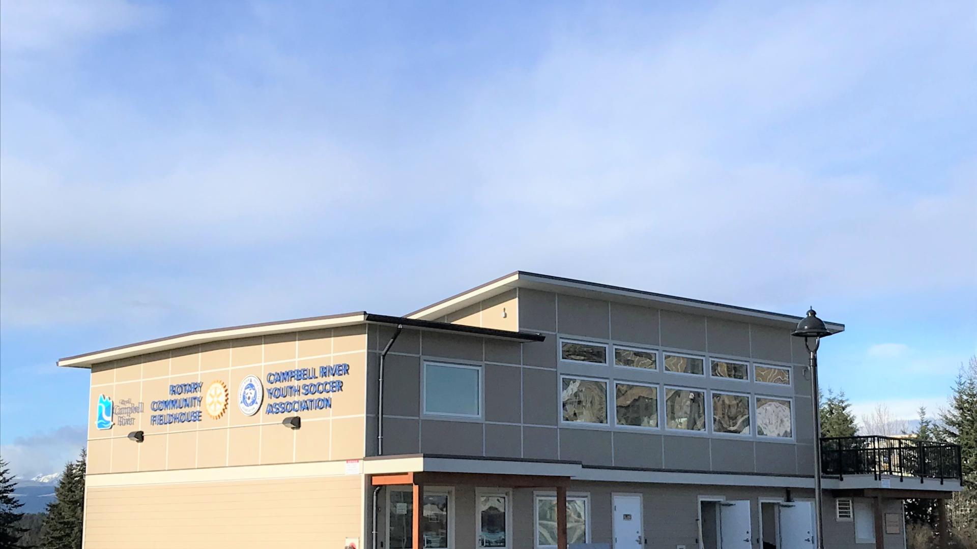 Two-story Rotary Fieldhouse building in Robron Park under a clear blue sky