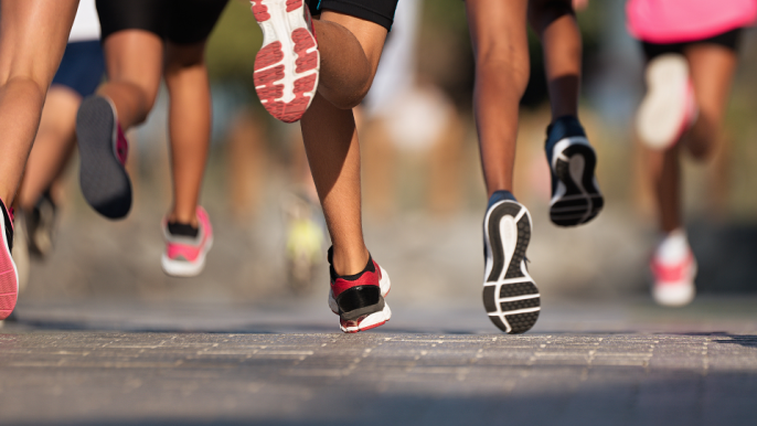 Multiple runners running along pavement.