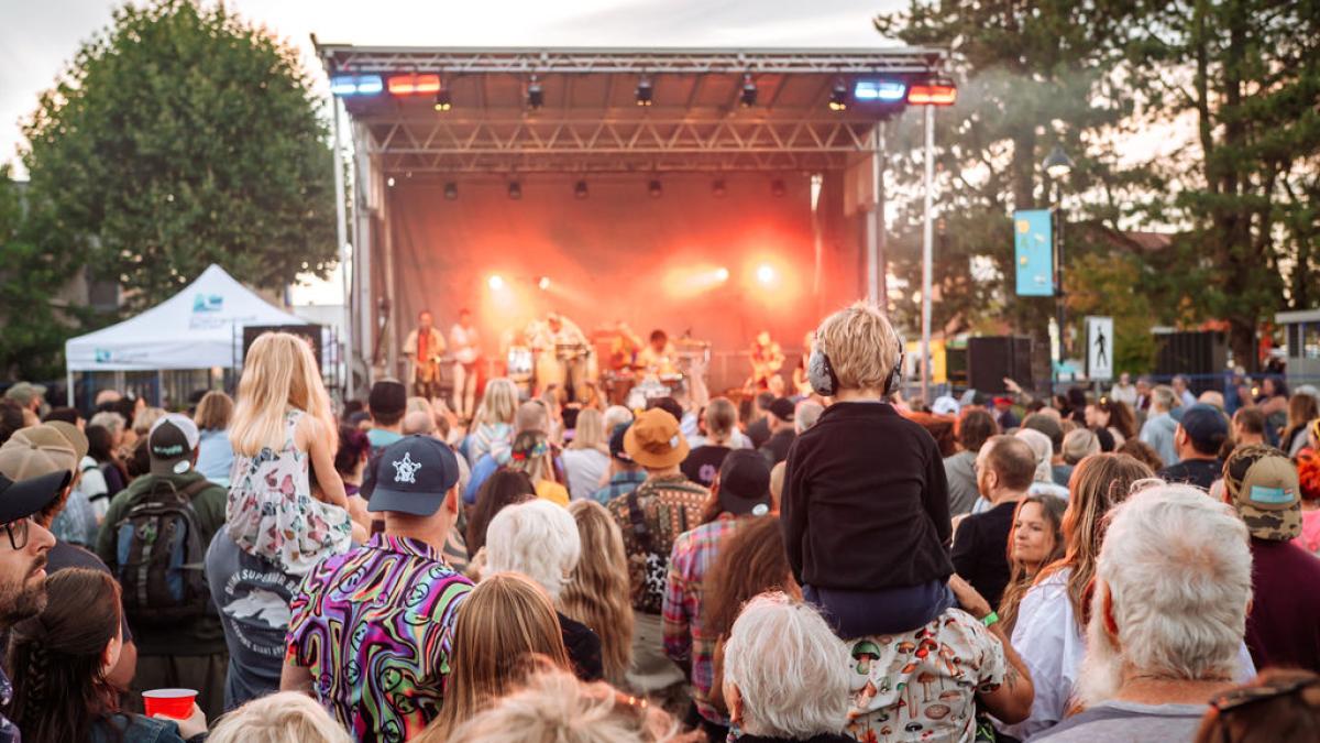Crowd at CR Live Streets watching a band perform on a brightly lit, colorful stage.
